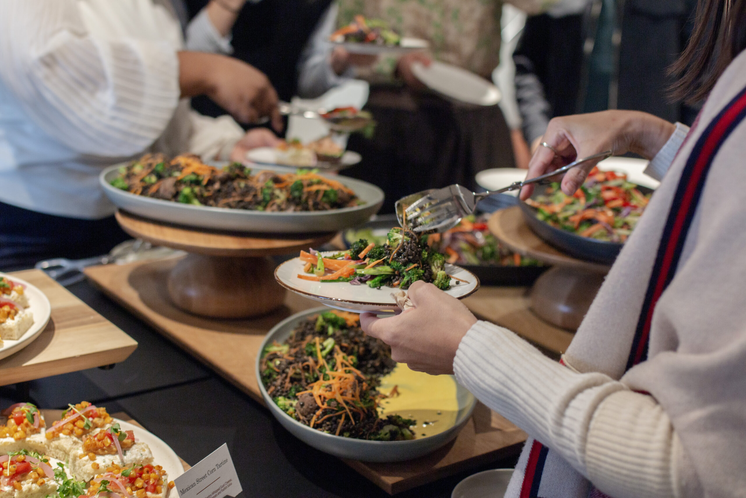 People serving food from event buffet