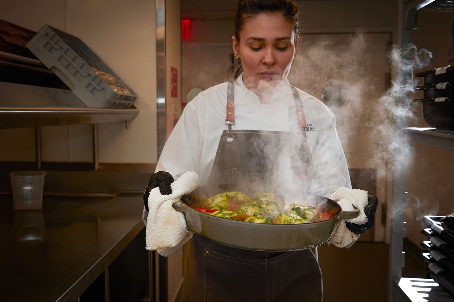 Executive Chef Diana Roldao Jacob de Souza carrying a prepared hot dish.