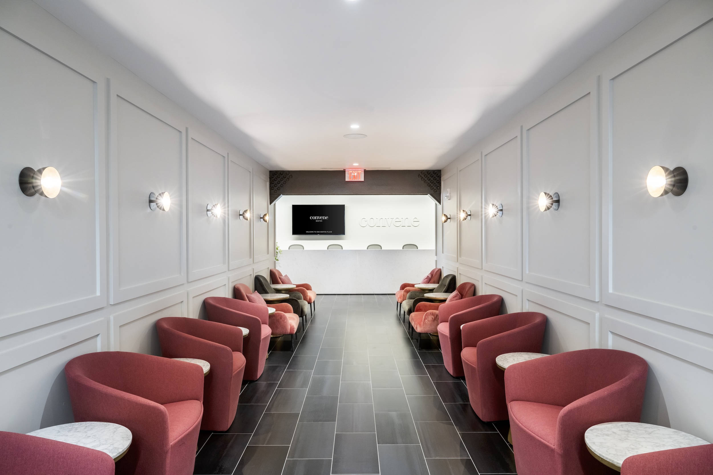 Convene welcome desk entrance with red chairs
